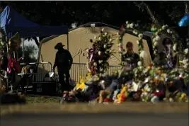  ?? ERIC GAY — THE ASSOCIATED PRESS FILE ?? A Texas Department of Public Safety officer keeps watch on in Uvalde, Texas, near a memorial outside Robb Elementary School created to honor the victims killed in last a school shooting.
