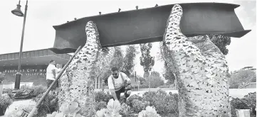  ??  ?? Abraham Galindo cleans the area around artist Heath Satow’s sculpture honouring victims of the Sept 11, 2001 World Trade Centre attacks in Rosemead, California. — AFP photo