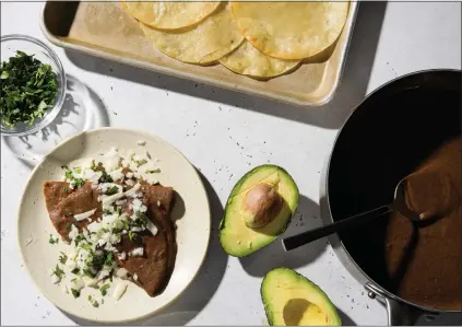  ?? MILK STREET VIA AP ?? This image released by Milk Street shows a recipe for black bean enfrijolad­as.