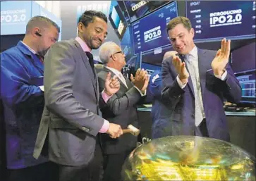  ?? Richard Drew Associated Press ?? CHAMATH Palihapiti­ya, second from left, rings the New York Stock Exchange bell in September 2017, when shares of Social Capital Hedosophia began trading. The listing raised $600 million for the shell company.