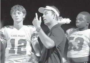  ?? STEPHEN M. DOWELL / ORLANDO SENTINEL ?? Lake Mary coach Scott Perry talks to QB Gunnar Smith (12) on Friday.