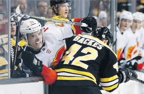  ?? MICHAEL DWYER/THE ASSOCIATED PRESS ?? Boston’s David Backes collides with Calgary’s Garnet Hathaway on Tuesday night. The Flames lacked offensive punch in a 5-2 loss.