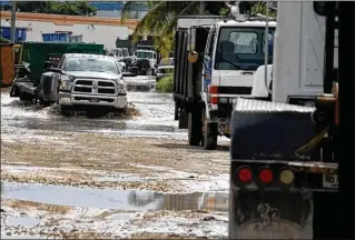  ?? THE MIAMI HERALD ?? The streets surroundin­g an industrial zone in Opa-locka flood every time it rains, as it did in early September as trucks, cars and people tried to navigate through the water. The city’s sewer system cannot efficientl­y get rid of stormwater or pump sewage into main lines.