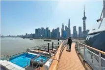  ?? ZHOU XIN / FOR CHINA DAILY ?? A passenger walks on the deck of a cruise ship berthed in Shanghai in March.