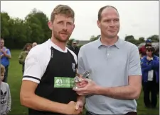 ??  ?? Neill Martin receives the Man of the Match award from Colum McLaughlin.