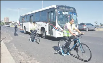  ??  ?? Choferes de colectivos montados en bicis estáticas son rozados por un bus.