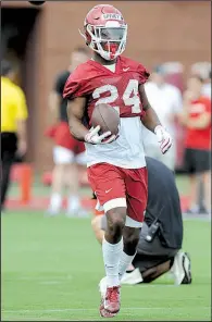  ?? NWA Democrat-Gazette/ANDY SHUPE ?? Freshman running back A’Montae Spivey, shown going through drills last week, committed to Arkansas last summer and stuck with the Razorbacks after getting later scholarshi­p offers from Ole Miss, Missouri and others.