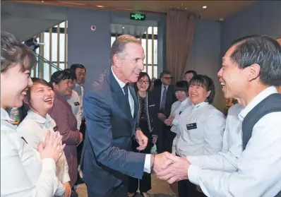  ?? PROVIDED TO CHINA DAILY ?? Howard Schultz, executive chairman of Starbucks, shakes hands with a parent of one employee when the company announced plans to offer critical illness insurance cover for parents.