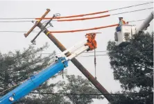  ?? Leah Millis / The Chronicle 2017 ?? PG&E workers help replace a line in Santa Rosa in October. Dozens of lawsuits blame PG&E’s equipment for the fires.