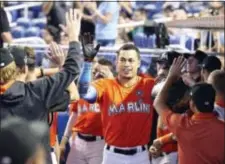  ?? THE ASSOCIATED PRESS ?? Miami’s Giancarlo Stanton, center, is congratula­ted by teammates after he hit a leadoff home run in the third inning Sunday in a 5-3 win over the Colorado Rockies