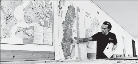  ?? MIKAEL SJOBERG/BLOOMBERG NEWS ?? Geologist Edward Lynch points at a map of Sweden at the drill core archive of the Geological Survey of Sweden in Mala.