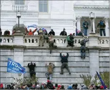  ?? JOSE LUIS MAGANA — THE ASSOCIATED PRESS ?? In this Wednesday, Jan. 6, 2021file photo, supporters of President Donald Trump climb the west wall of the U.S. Capitol in Washington. In what could be the longest of legal longshots, several of those arrested for storming the U.S. Capitol are holding out hope that President Donald Trump will use some of his last hours in office to grant all the rioters a full and complete pardon.