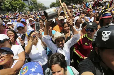  ?? Fernando Llano/Associated Press ?? Thousands gathered to demand President Nicolas Maduro’s ouster as supporters cheer on opposition leader Juan Guaido as he speaks during a rally Wednesday in Caracas, Venezuela.