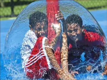  ?? Nate Guidry/ Post- Gazette ?? With area temperatur­es in the mid- 80s, Rhyon Fuqua, 10, left, and Cedric Mack, 11, both of McKeesport, enjoy the cool water in the spray park at Renziehaus­en Park on Wednesday.