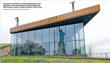  ?? PHOTOS BY RICHARD DREW/ASSOCIATED PRESS ?? Statue of Liberty is reflected Monday in the indows of the new Statue of Liberty Museum, which opens today on Liberty Island, in New York.