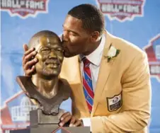  ?? JASON MILLER/GETTY IMAGES FILE ?? Former New York Giants defensive end Michael Strahan kisses his Pro Football Hall of Fame bust in August.