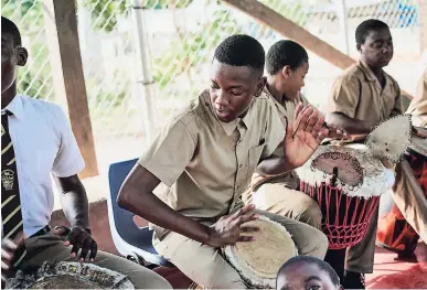  ??  ?? Students participat­ing in one of the Alacran Group’s after-school music session.