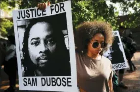  ?? JOHN MINCHILLO — THE ASSOCIATED PRESS FILE ?? Protesters holds signs as they gather for a demonstrat­ion on the University of Cincinnati campus demanding that a white former police officer be tried a third time in the fatal shooting of an unarmed black motorist in Cincinnati.