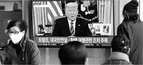  ?? AP PHOTOS ?? People watch a TV screen showing a live broadcast of US President Donald Trump’s speech at the Seoul Railway Station in South Korea, on Thursday, March 12.