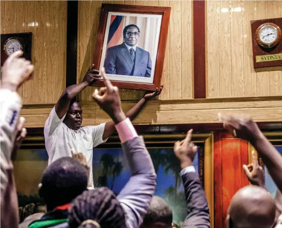  ?? Foto: LEHtikUva/JEkESai NJikiZaNa ?? en era är över. Lyckliga zimbabwier tog ned porträttet av sin president då Robert Mugabe meddelat att han avgår efter 37 år vid makten.