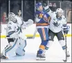  ?? SETH WENIG — THE ASSOCIATED PRESS ?? Sharks goaltender Martin Jones, left, tries to see past teammate Erik Karlsson, right, and the Islanders’ Matt Martin on Monday.