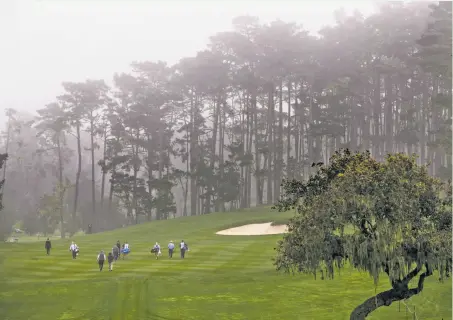  ?? Photos by Michael Macor / The Chronicle ?? David Duval’s group heads up a foggy 10th fairway at Spyglass Hill during the third round of the AT&amp;T Pebble Beach Pro-Am.