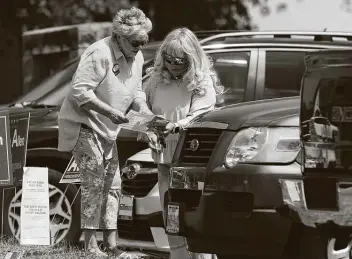  ?? Jerry Lara / Staff photograph­er ?? Two women look at a sample ballot outside the Brook Hollow Library voting site Tuesday. Countywide, more than 31,600 voters showed up.