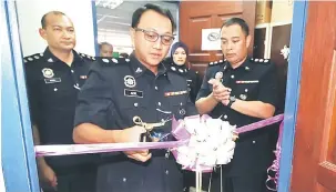  ??  ?? RASMI: Aidil memotong reben sebagai gimik perasmian OSC IPD Padawan.