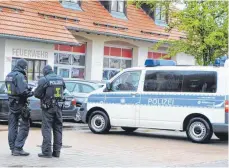  ?? FOTO: STEFFEN LANG ?? Zwei Beamte der Bundespoli­zei am Freitagvor­mittag vor dem Feuerwehr- und DRK-Haus in Aichstette­n.