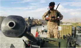  ?? July. Photograph: Anadolu Agency/Getty Images ?? An Afghan soldier keeps watch on a Humvee tank after US forces left Bagram airbase on 5