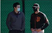  ?? SUZANNA MITCHELL — SAN FRANCISCO GIANTS ?? San Francisco Giants general manager Scott Harris, left, and manager Gabe Kapler talk in the bullpen during a team workout at Scottsdale Stadium on February 19, 2021.