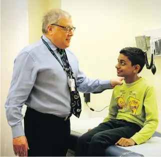  ?? JOHN MAHONEY/MONTREAL GAZETTE ?? Montreal gastroente­rologist Ernest Seidman examines 12-year-old patient Prassanna Chelliah at the Montreal Children’s Hospital.