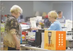  ?? (File Photo/NWA Democrat-Gazette/Charlie Kaijo) ?? Suzanne Evans of Bella Vista (right) greets Glenda Redenius of Bella Vista during the setup for the 2019 “Flea.” May 20-21 will mark the 27th edition of the fundraiser that benefits women’s and children’s charities in Northwest Arkansas.