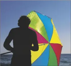  ?? AP PHOTO/JAE C. HONG ?? A man folds his umbrella on the beach on Aug. 7, 2018, in Laguna Beach, Calif.