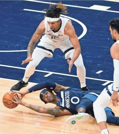  ?? JIM MONE/AP ?? The Minnesota Timberwolv­es’ D’angelo Russell (0) tries to grab the ball after falling while being double-teamed by Memphis Grizzlies defenders Brandon Clarke, left, and Dillon Brooks in the first half on Wednesday in Minneapoli­s.