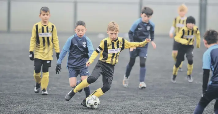  ??  ?? Russell Foster under-9s Spring Cup action between Washington AFC Tigers (navy) and Hebburn Town Blues Barca, played at Houghton Kepier.