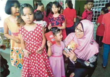  ??  ?? FUZIAH menyampaik­an sumbangan kepada penghuni pada Sambutan Perayaan Tahun Baru Cina di Rumah Kebajikan Rapha Children’s Home, semalam.