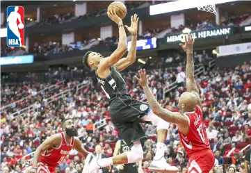  ??  ?? Milwaukee Bucks forward Giannis Antetokoun­mpo (top) shoots the ball as Houston Rockets forward PJ Tucker (17) defends during the third quarter at Toyota Centre. — USA TODAY Sports photo