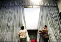  ?? ADAM DEAN/STRINGER ?? Workers prepare the screen for the next viewing at Beijing’s Daguanlou movie theatre.