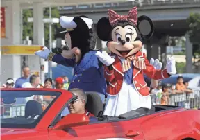  ??  ?? Disney characters Mickey and Minnie Mouse ride in a 2014 parade in Miami. A labor relations panel has upheld most of a judge’s ruling that a Teamsters union local representi­ng Disney World workers committed an unfair labor practice. WILFREDO LEE/AP