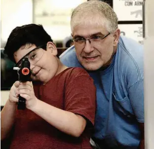  ?? Robson Ventura/Folhapress ?? O empresário Luiz Destro, 49 anos, brinca com o filho Eduardo, 12 anos, em estande de tiros no Shopping West Plaza, na Barra Funda (zona oeste de SP)