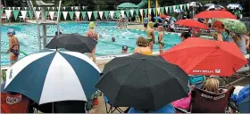  ?? MEDIANEWS GROUP FILE PHOTO ?? Parents watch warm-ups from beneath umbrellas during the dual meet between Hatfield and Lansdale at White’s Park Pool on June 25, 2015.