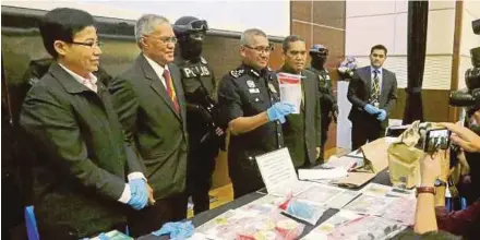  ?? PIC BY ROSDAN WAHID ?? Inspector-General of Police Tan Sri Mohamad Fuzi Harun (fourth from left) showing parapherna­lia used to make improvised explosive devices seized from the three suspects, at Bukit Aman in Kuala Lumpur on Tuesday.