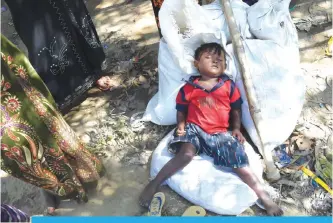  ??  ?? UKHIA: A young Rohingya Muslim refugee who entered Bangladesh by boat rests as he waits to go to refugee camps near the Thankhali refugee camp in Bangladesh’s Ukhia district.—AFP