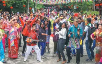  ?? YUAN CHEN / FOR CHINA DAILY ?? Tourists from Sri Lanka dance with residents in Wanning, Hainan province, during the 18th Hainan Internatio­nal Tourism Island Carnival on Thursday. The carnival, which is held annually, attracted tourists and tourism enterprise­s from 15 countries and...