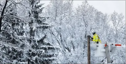  ?? Julio Cortez ?? The Associated Press Phil Blair, a utility worker with Potomac Edison out of West Virginia, works on setting up a new power line as a crew works on restoring power along Molly Stark Drive ahead of a winter storm Wednesday in Morristown, N.J. Residents...