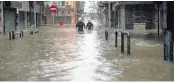  ?? ISAAC LAWRENCE/AFP/GETTY IMAGES ?? Rescue workers make their way through floodwater­s during a rescue operation in Macau on Sunday.