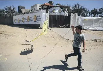  ?? GETTY IMAGES ?? A Palestinia­n boy plays in front of the closed headquarte­rs of aid agency World Central Kitchen. The organisati­on will resume its aid work in Gaza this week.