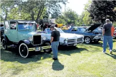  ?? LAURA BARTON/WELLAND TRIBUNE ?? People take a look at a few of the over 200 cars that were on site at Pelham’s Centennial Park, home to the Fenwick Lions Club. On Saturday, the club hosted a classic car show and raffle, with funds going towards Lions’ Club community initiative­s.