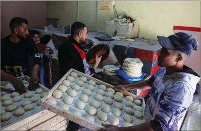  ?? SAID KHATIB / AFP ?? Palestinia­ns work in a traditiona­l bakery in Rafah, in the southern Gaza Strip, on March 21.